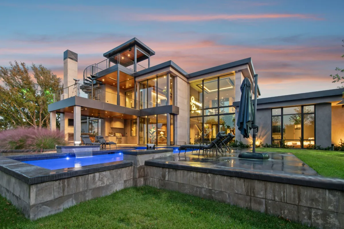 Modern luxury property photographed at dusk with lit interiors and pool