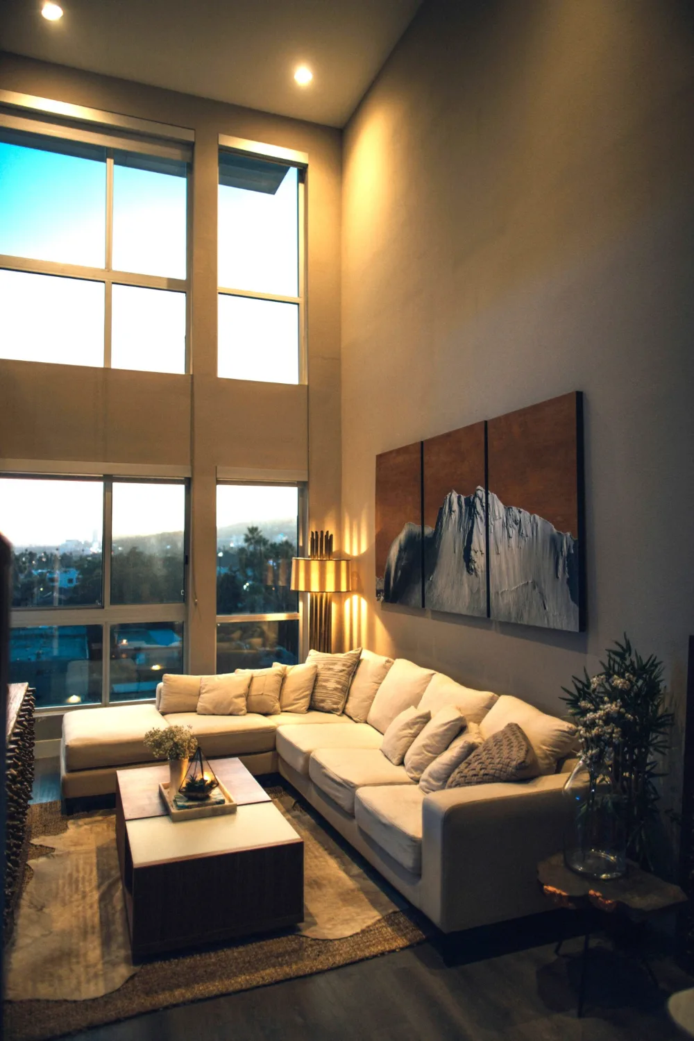 Warmly lit modern living room at dusk with city views, the kind of property VizCraft edits video for