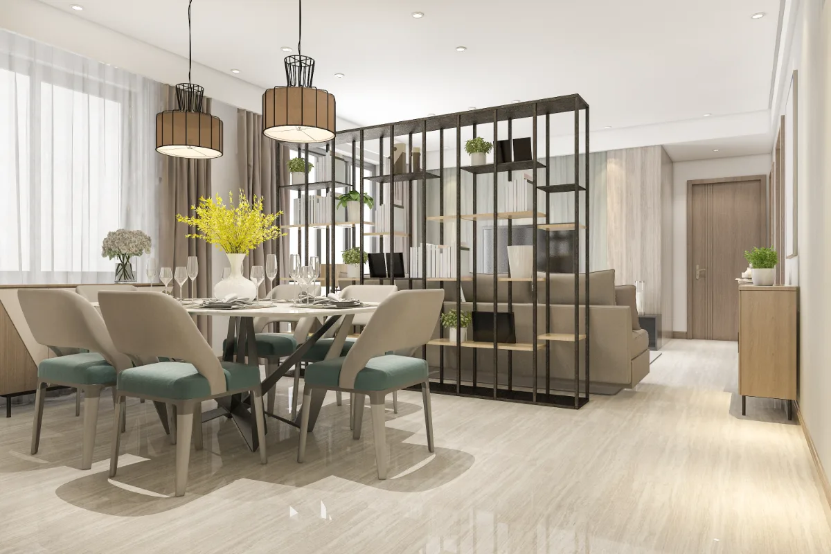 Staged open-plan dining area with a round table, green upholstered chairs, pendant lights and an open shelving divider